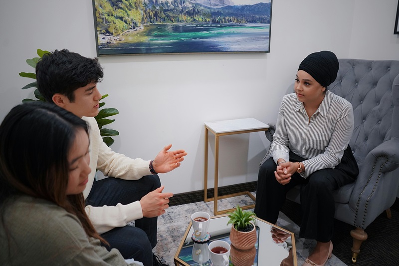 three people sitting down and talking