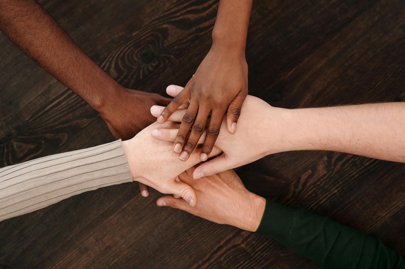 five people holding hands